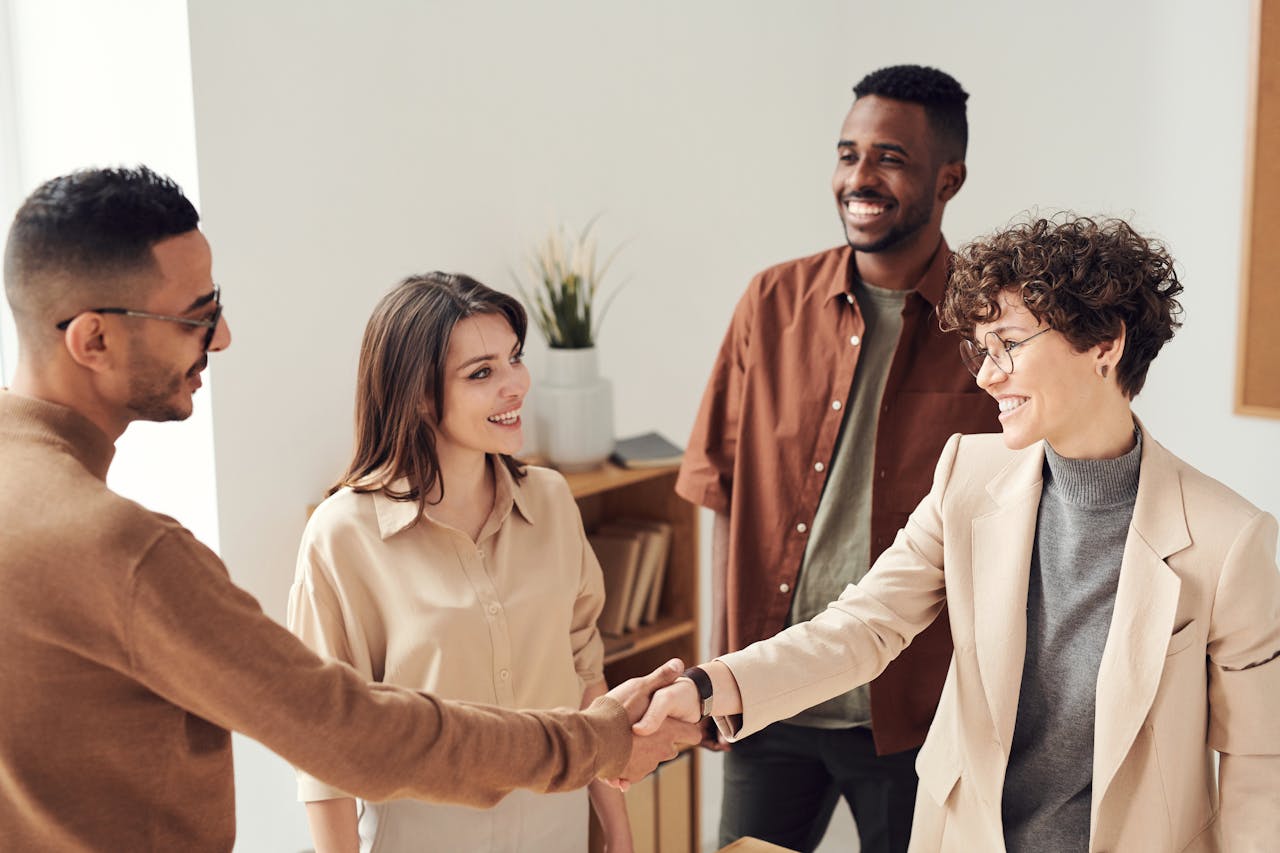 A group of business professionals smiling and shaking hands.